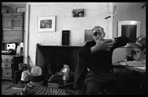 W. Eugene Smith, seated at a desk in his home