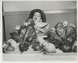 Young client eating dinner with performers at Thanksgiving celebration