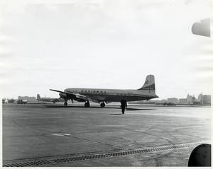 Unidentified man in uniform walking away from National Airlines plane, likely at Logan Airport