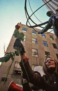 Gloria Steinem raising a rose
