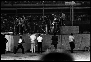 Beatles concert at Shea Stadium: Beatles in performance on stage: George Harrison and John Lennon up front, Ringo Starr on drums (l. to r.)