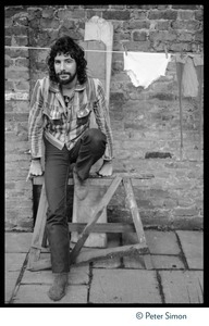 Cat Stevens: full-length portrait, seated by a laundry line on Carly Simon's back door patio