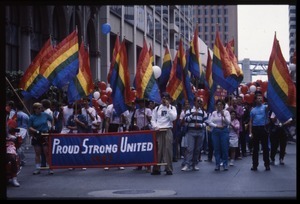 Group marching in the San Francisco Pride Parade with pride flags and banner reading 'Proud / strong / united 1987'