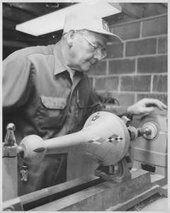 John Ryan working on wooden lamp in carpentry shop
