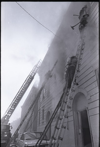 Firefighters climbing ladders to burning building in Dorchester