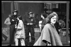 Police watch as antiwar demonstrators picket in front of the John F. Kennedy Federal Building