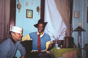 Photographs of Marsha P. Johnson Wearing a Fedora, Striped Sweater and Red Tie, Sitting with Another Person