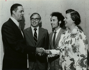 Randolph W. Bromery shaking hands with unidentified woman, while two unidentified men look on