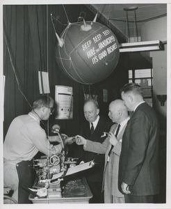 A trainee shows a group his work at the 1957 Thumbs Up Awards event