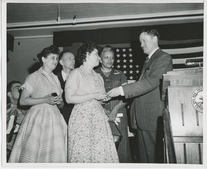 Unidentified man handing gifts to a clients at graduation exercises