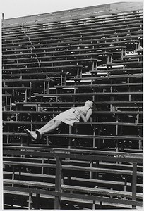 Student asleep on Boston College bleachers