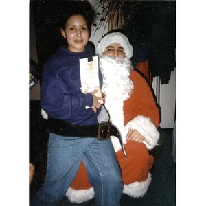A young woman perches on Santa's lap.