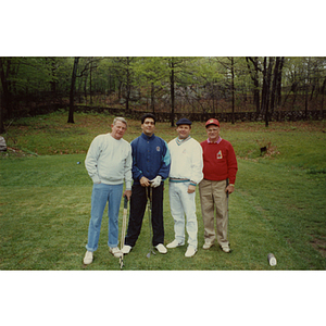 A four-man golf team posing on the golf course at a Boys and Girls Club Golf Tournament