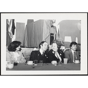 Two guests, seated at the head table, laugh together while another looks on during a Boys and Girls Club event at the South Boston Clubhouse