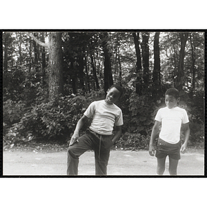 A Boy dancing in a group activity while another boy looks on