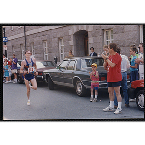 A man runs as spectators cheer him on during the Bunker Hill Road Race