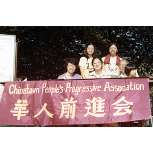 Suzanne Lee and Henry Wong sit with others at a Chinese Progressive Association information booth at a Dragon Boat Festival