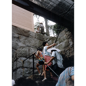 Association members climb a staircase from underground