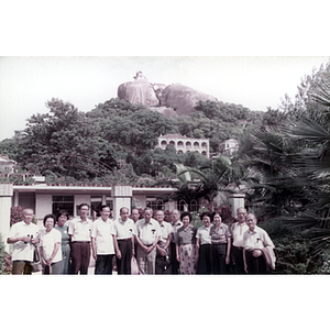 Men and women stand in front of a Chinese building