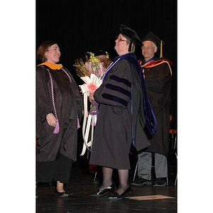 Student presents flowers to School of Nursing faculty member at convocation