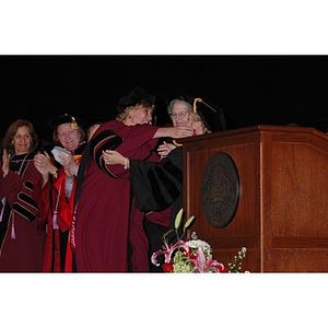 Two faculty members hug at School of Nursing convocation