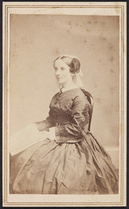 Half-length portrait of Mary Perkins Olmsted, facing three-quarters to the left, seated on a chair, holding papers, location unknown, 1863