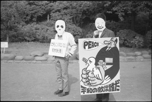 Protesters carrying sign depicting President Johnson mouthing words of peace while crushing a dove