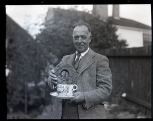 Henry A. Ellis and the doughnut: Ellis dunking an oversized donut into oversized cup of coffee