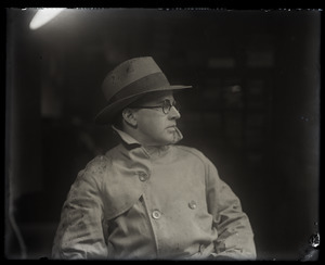 Half-length portrait of James Moulton, profile, wearing trench coat and fedora