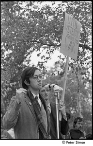 Resistance rally: Raymond Mungo speaking at rally on Boston Common, man behind holding sign reading 'UMB Veterans against the war'