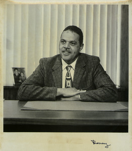Randolph W. Bromery sitting indoors, behind desk
