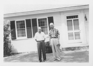 Dr. John Van Roekel and unidentified man standing in front of white house