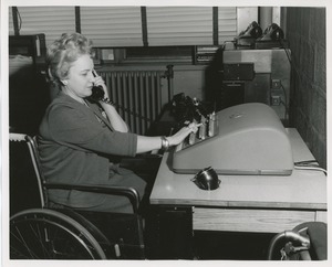 Mrs. Frances Marsala seated in her wheelchair operating a machine for a telephone answering service