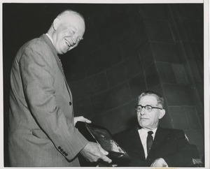 President Dwight D. Eisenhower handing a plaque to an unidentified man in a wheelchair