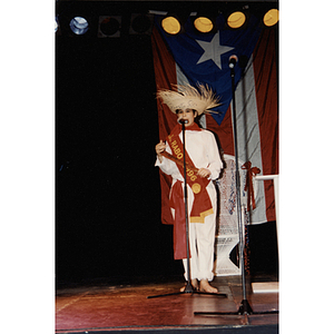 A woman in a straw hat and Gurabo sash speaks into a microphone at the 1996 Puerto Rican Festival