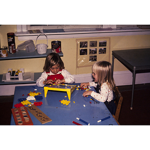 Young children sitting at a table playing with toys