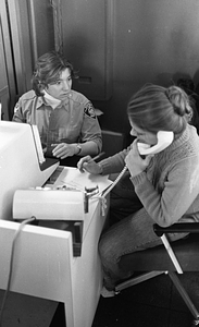 Unidentified Emergency Medical Technician and unidentified woman using telephone