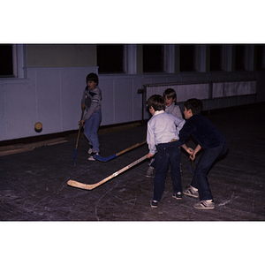 Boys playing hockey indoors