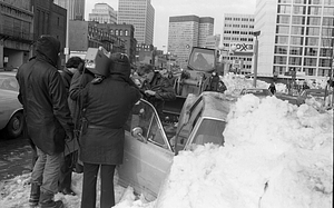 Unidentified men holding film cameras in front of cars buried in snow