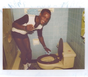 A Photograph of Marsha P. Johnson Cleaning a Toilet and Smiling at the Camera