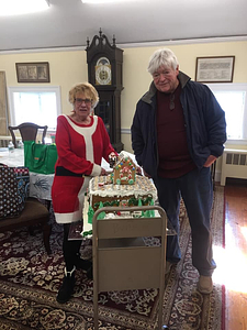 Mary and Tom Connolly, of Winthrop, prepare the Library Staff's entry in the Gingerbread House competition, for transport.