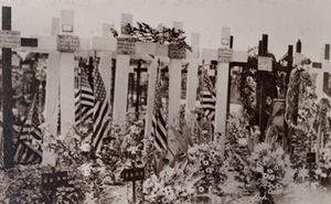 Close-up view of wooden crosses decorated with flowers and flags marking graves of American soldiers, Châlons-en-Champagne, 1919