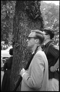 Man with an umbrella over his shoulder at a demonstration in front of the White House