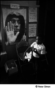 African American boy in front of a poster of Stokely Carmichael, the Liberation School