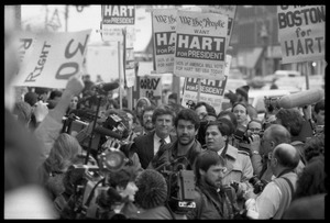 Gary Hart walking through a crowd of press and supporters after renewing his bid for the Democratic nomination for the presidency