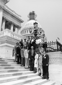 Congressman John W. Olver (4th from right) and visitors, posed on the steps of the United States Capitol building (scaffolding on top of dome)