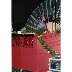 Young woman in a red dress walks across the stage during the 1998 Festival Betances beauty contest.