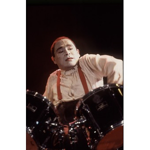Heavily made-up drummer on stage during a Café Teatro performance.