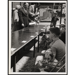Several boys sitting with their dogs as judges score them in a Boys' Club Pet Show
