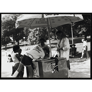 A teenage boy serves ice juice from a food cart on Boston Common